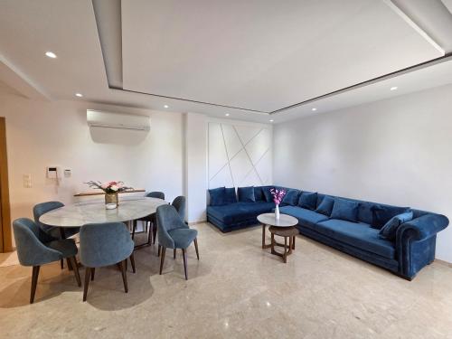a living room with a blue couch and a table at Luxurious Apartment in Sousse
