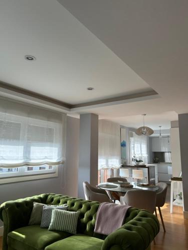 a living room with a green couch and a kitchen at Bournacell 16 in Cambados