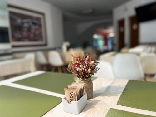 a table with a vase of flowers on top of it at Alpino Hotel in Buenos Aires