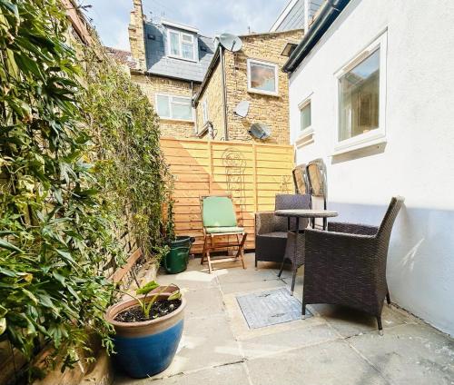 a small patio with two chairs and a table at Courtyard Oasis in London
