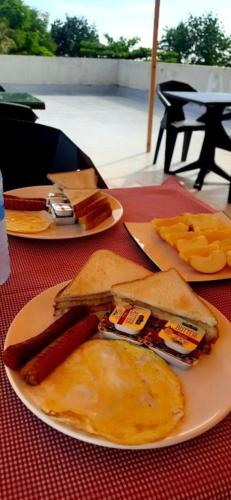 a table with plates of food on a red table at Dhiffushi Tourist Hotel in Dhiffushi