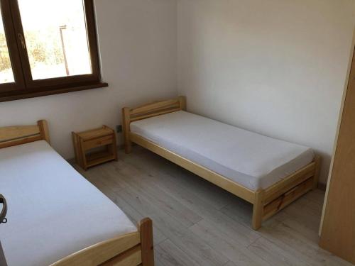 a small room with two beds and a window at Ubytování u Moravců - Dolní Tošanovice in Dolní Tošanovice