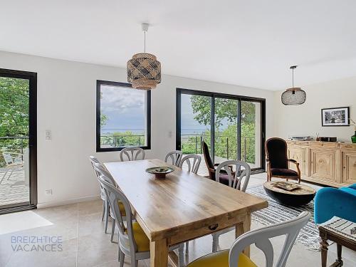 une salle à manger avec une table et des chaises dans l'établissement Maison Anémone - Vue mer - Crozon, Bretagne, à Crozon