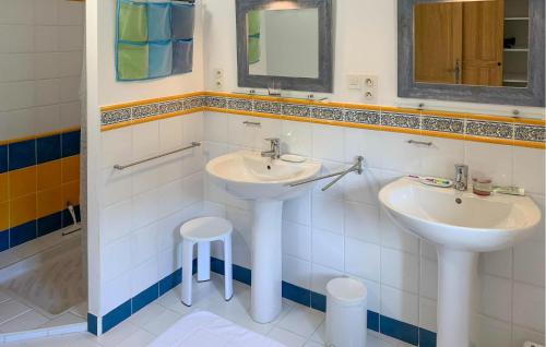 a bathroom with two sinks and a stool in it at Maison Vue Panoramique in Plaisians