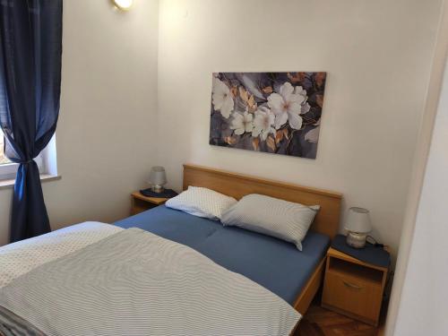 een slaapkamer met een bed en een schilderij aan de muur bij Apartma San Marino in Novi Vinodolski