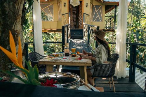a woman sitting at a table on a porch at Burú Nature Hotel in Leticia
