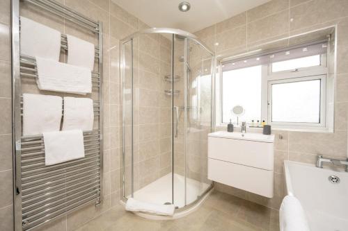 a bathroom with a shower and a toilet and a sink at Luxury 5 Bed House With Parking in Solihull
