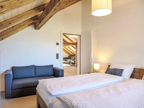 a bedroom with a bed and a blue couch at Apartment Huus Chloster- Apt Büel by Interhome in Krattigen