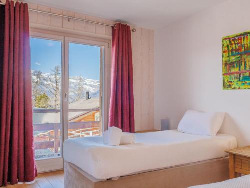 a bedroom with a bed and a large window at Chalet Chalet Roose by Interhome in Plan Fey