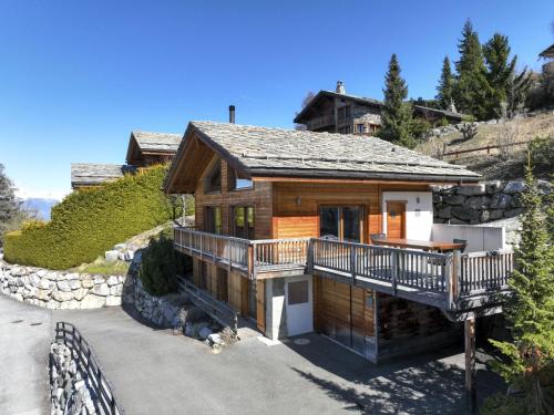 a log home with a deck on a mountain at Chalet Chalet Roose by Interhome in Plan Fey