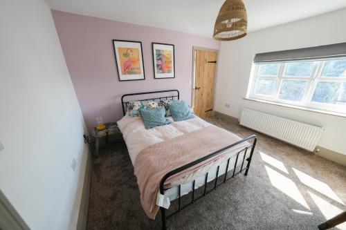 a bedroom with a bed with blue pillows at Plumtree Cottage in Farnsfield