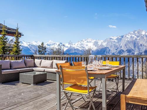 a deck with a table and chairs and a couch at Chalet Chalet Roose by Interhome in Plan Fey