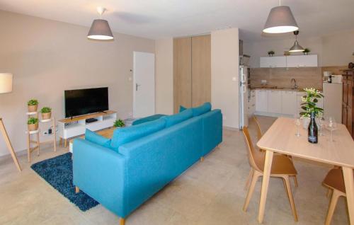 un salon avec un canapé bleu et une table dans l'établissement Charmant Mazet Provençal, à Mazan