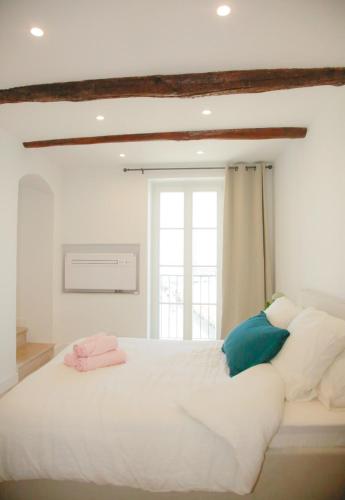 une chambre avec un grand lit blanc avec une fenêtre dans l'établissement 3BR on the Remparts of Antibes - Sea & Mountain View, à Antibes