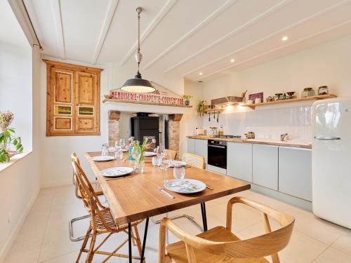- une cuisine avec une table à manger en bois et des chaises dans l'établissement Holiday Home l'Ansnevilla by Interhome, à Anneville-sur-Mer