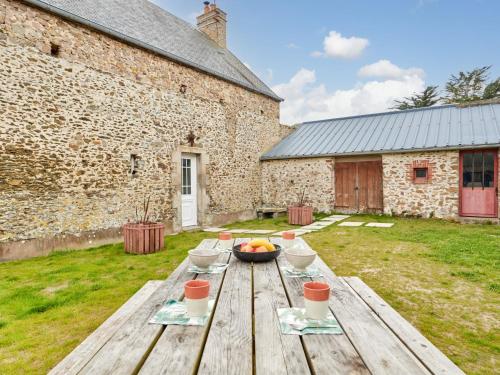 - une table en bois avec un bol de fruits dans l'établissement Holiday Home l'Ansnevilla by Interhome, à Anneville-sur-Mer