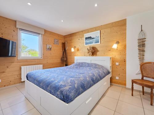 une chambre avec un lit, une télévision et une chaise dans l'établissement Holiday Home Chez Boubou by Interhome, à Saint-Laurent-sur-Mer
