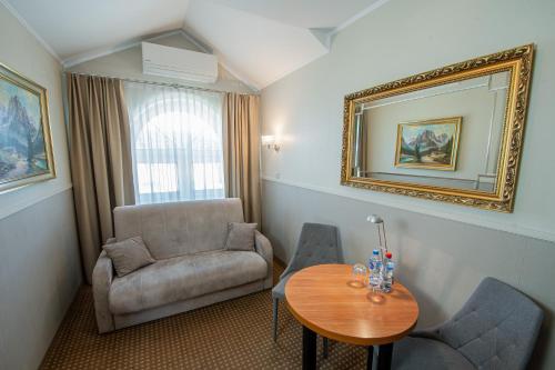 a room with a chair and a table and a mirror at Moris Boutique Beach Hotel in Gdańsk