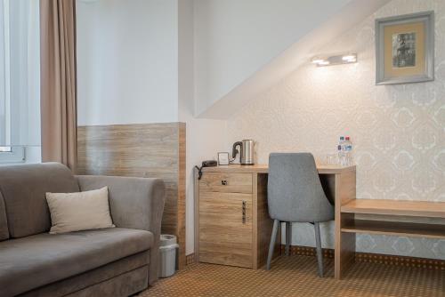 a room with a couch and a desk and a chair at Moris Boutique Beach Hotel in Gdańsk