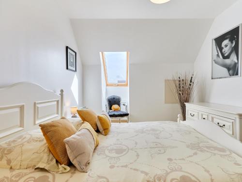 - une chambre blanche avec un lit et des oreillers dans l'établissement Holiday Home Caprera by Interhome, à Denneville
