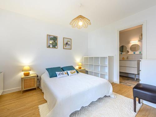 a white bedroom with a bed and a chair at Apartment Port Haliguen Plaisance-2 by Interhome in Quiberon