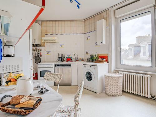 une cuisine avec une table et des chaises et une fenêtre dans l'établissement Apartment L'écluse-3 by Interhome, à Dinard