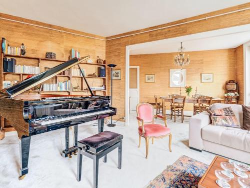 a living room with a piano and a dining room at Apartment L'écluse-3 by Interhome in Dinard