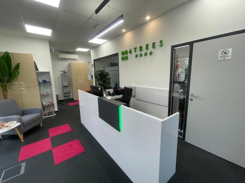 Un cubículo de oficina con un mostrador blanco y un escritorio. en 4TREES Airport Apartments and Rooms, en Velika Gorica