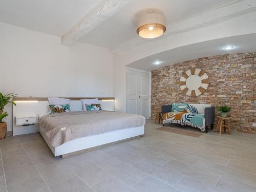 une chambre avec un lit et un mur de briques dans l'établissement Apartment Hameau de Guerrevieille by Interhome, à Grimaud