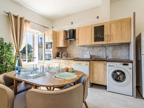 une cuisine avec une table en bois et un lave-linge dans l'établissement Apartment Hameau de Guerrevieille by Interhome, à Grimaud