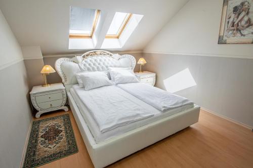 a bedroom with a white bed with a skylight at Moris Boutique Beach Hotel in Gdańsk