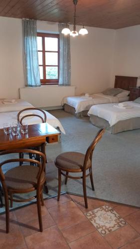 a room with two beds and a table and chairs at Penzion Ztracený mlýn in Slapy