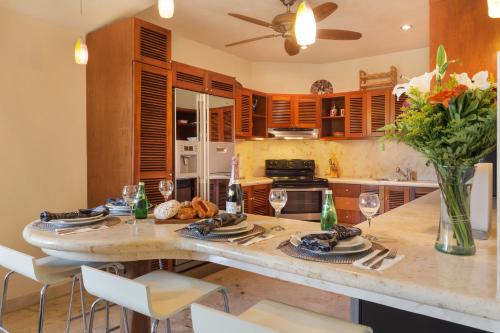 a kitchen with a table with plates and wine glasses at Porto Playa Condo Hotel and Beach Club in Playa del Carmen