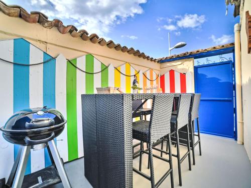 un bar avec des chaises sur un balcon avec un mur coloré dans l'établissement Holiday Home Cheray 1 by Interhome, à Saint-Georges-dʼOléron