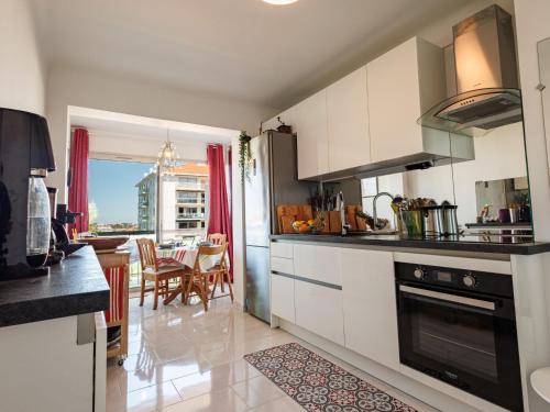 une cuisine avec des placards blancs et une salle à manger dans l'établissement Apartment Parc Euzkadi-3 by Interhome, à Biarritz