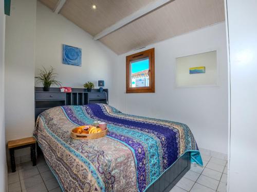 une chambre avec un lit avec un bol de fruits dessus dans l'établissement Holiday Home Les Maisons de la Plage-13 by Interhome, au Grau-du-Roi