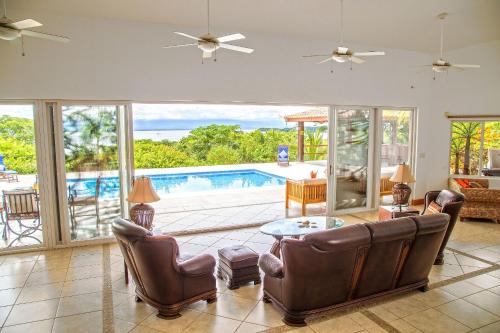 a living room with a view of a swimming pool at Villas Roma Del Mar in Playa Naranjo