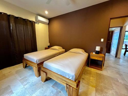 a bedroom with two beds and a mirror at Villas Roma Del Mar in Playa Naranjo