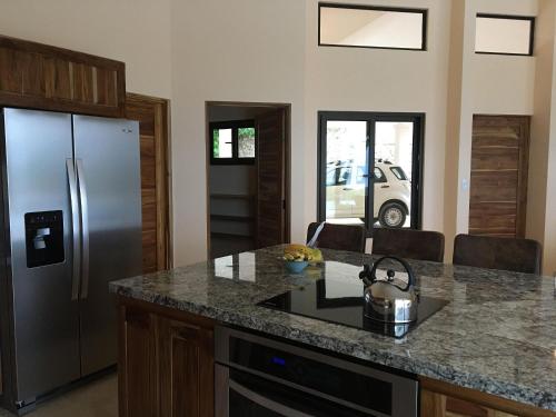 a kitchen with a stainless steel refrigerator and a counter at Villas Roma Del Mar in Playa Naranjo