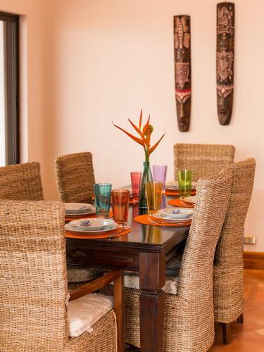 a dining room with a wooden table and chairs at Villas Roma Del Mar in Playa Naranjo