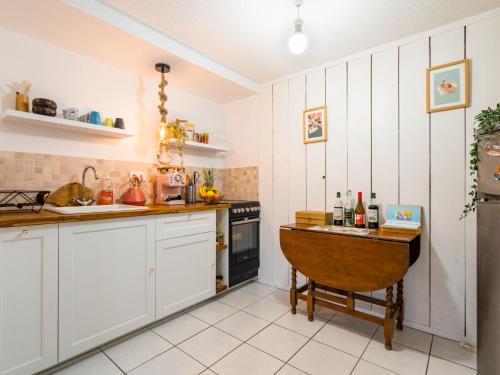 une cuisine avec des armoires blanches et une table en bois dans l'établissement Apartment Long Beach by Interhome, à Anglet