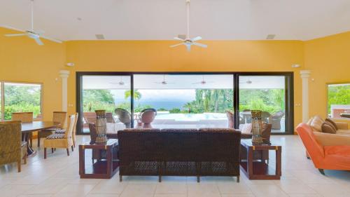 a living room filled with furniture and a large window at Villas Roma Del Mar in Playa Naranjo