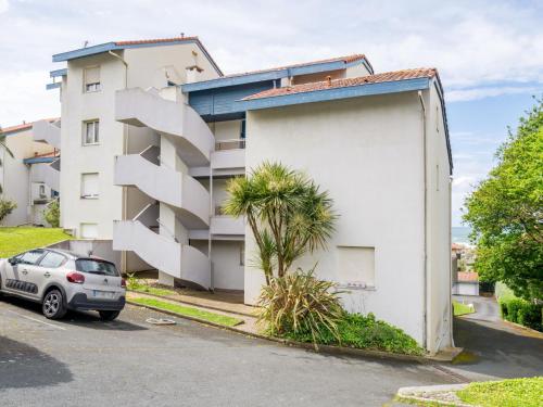 un bâtiment blanc avec un escalier à côté d'une voiture dans l'établissement Apartment Long Beach by Interhome, à Anglet