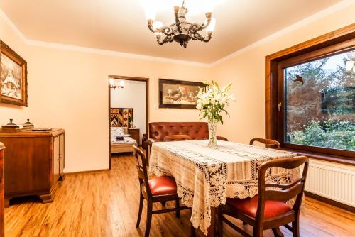a dining room with a table and chairs and a window at Willa Stróża in Myślenice