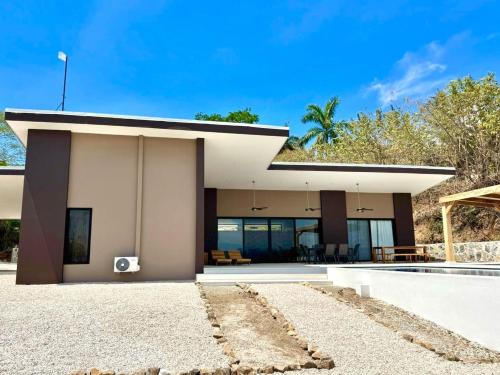 a modern house with a view of the backyard at Villas Roma Del Mar in Playa Naranjo
