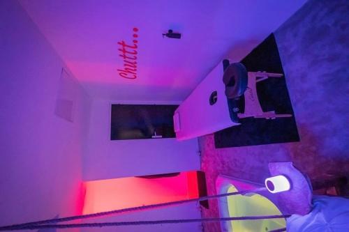 une pièce avec des lumières roses et une personne sur un skateboard dans l'établissement Test, à Lyon