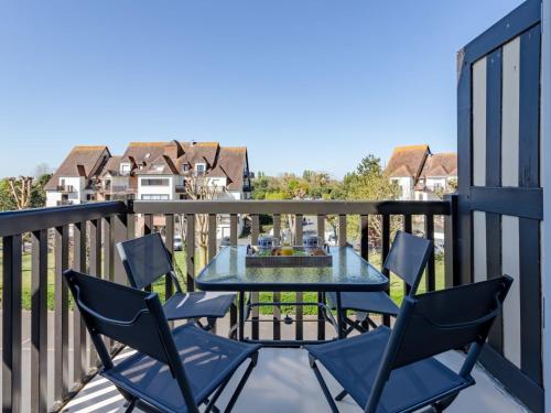 un patio avec une table et des chaises sur un balcon dans l'établissement Apartment Fleur Marine-36 by Interhome, à Cabourg