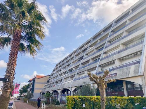 un bâtiment avec un palmier devant dans l'établissement Apartment Les Huniers-4 by Interhome, à Arcachon