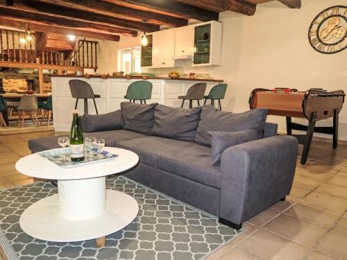 un salon avec un canapé bleu et une table dans l'établissement Holiday Home La Meunière by Interhome, à Le Gouray
