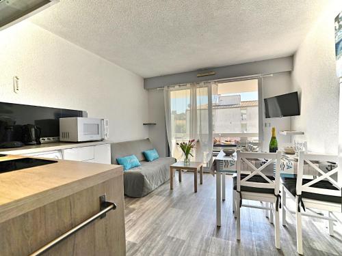une cuisine et un salon avec un canapé et une table dans l'établissement Apartment La Palmeraie by Interhome, à La Palmyre
